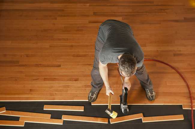 Hardwood Flooring professional installing tongue and groove flooring