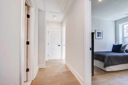 A bedroom and a hallway with white oak hardwood floors