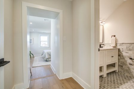 A kitchen, hallway and master bedroom with hardwood floors
