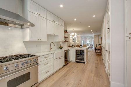 A kitchen with white cabinets and oak rustic brushed floors